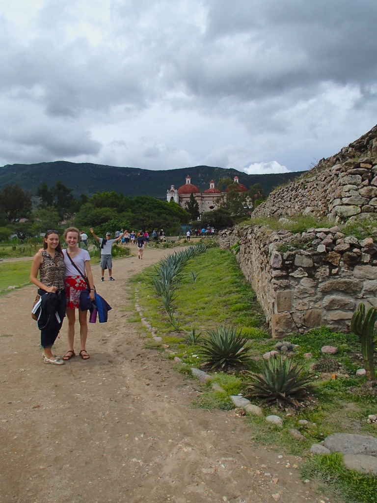 Sarah and Clara with the walls of the ruins on their right and the Catholic Church in the background